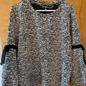 Black and white blouse, black bows on elbow. Baggy arms.